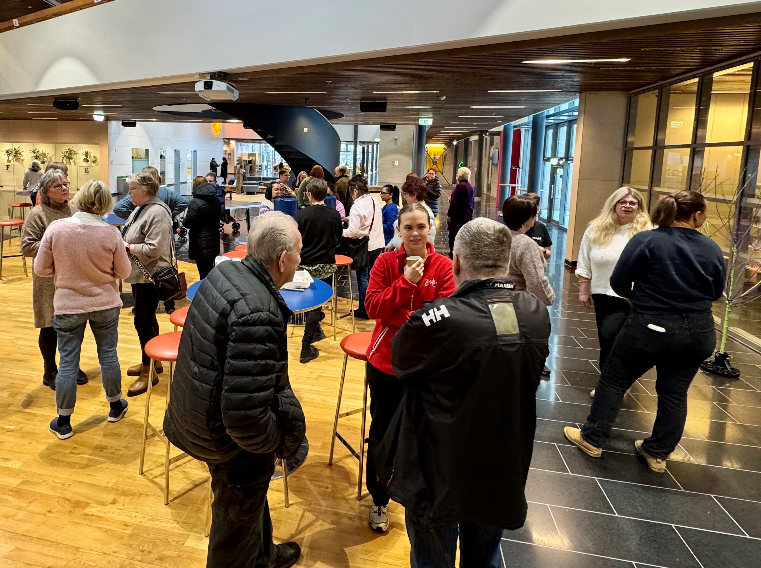 Bilde av mange deltakere som var med under kick-off av Livsgledehjem. Her mingler de og prater sammen på Sentrum videregående skole.